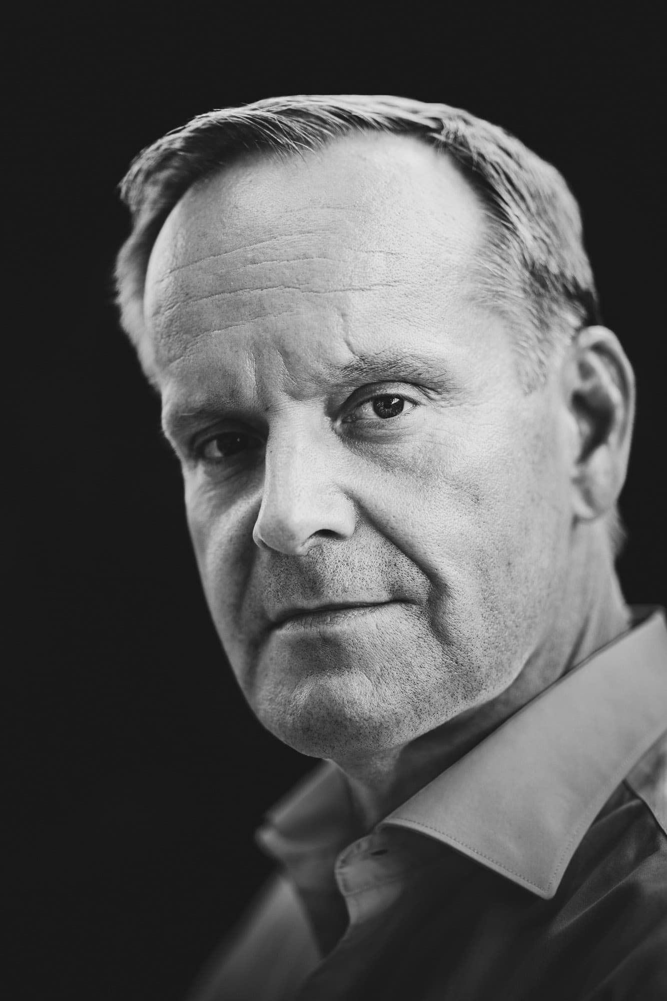 executive studio headshot in palma, man with serious expression, dark background, clean retouch